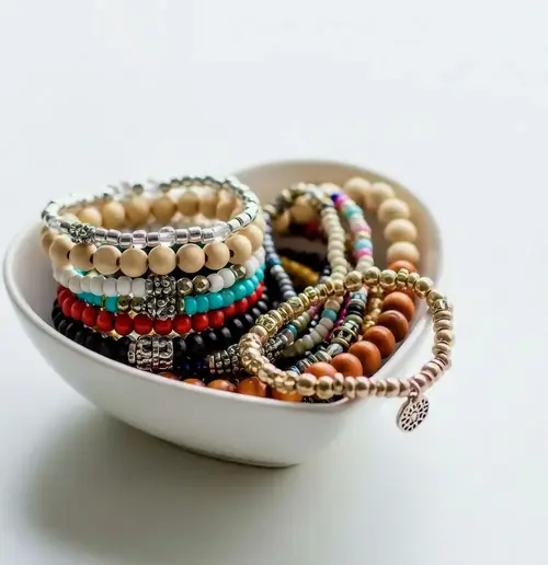 Teilnehmerinnen gestalten eigenen Perlenschmuck in einem Workshop.